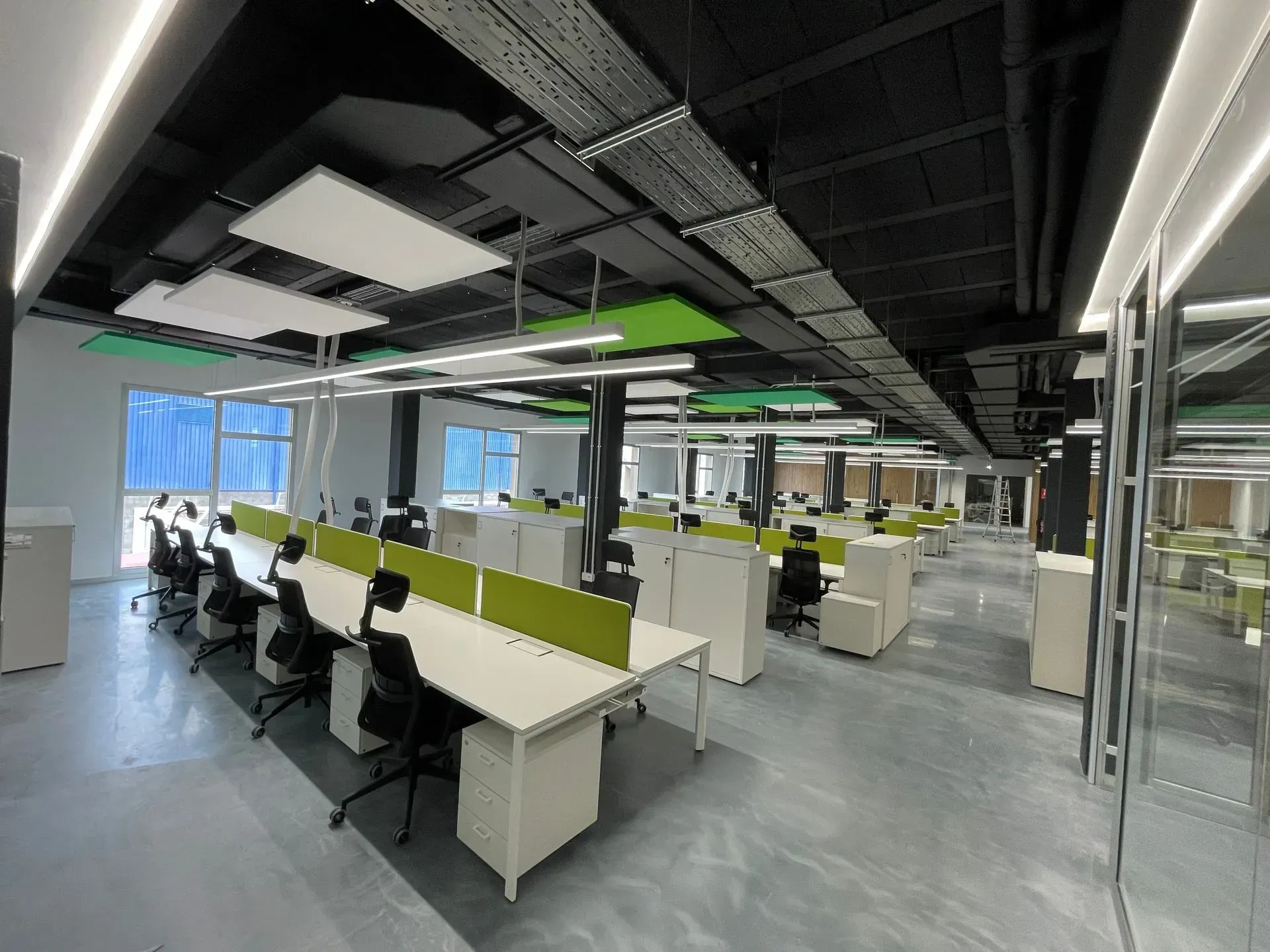 Una oficina grande con muchos escritorios y sillas.