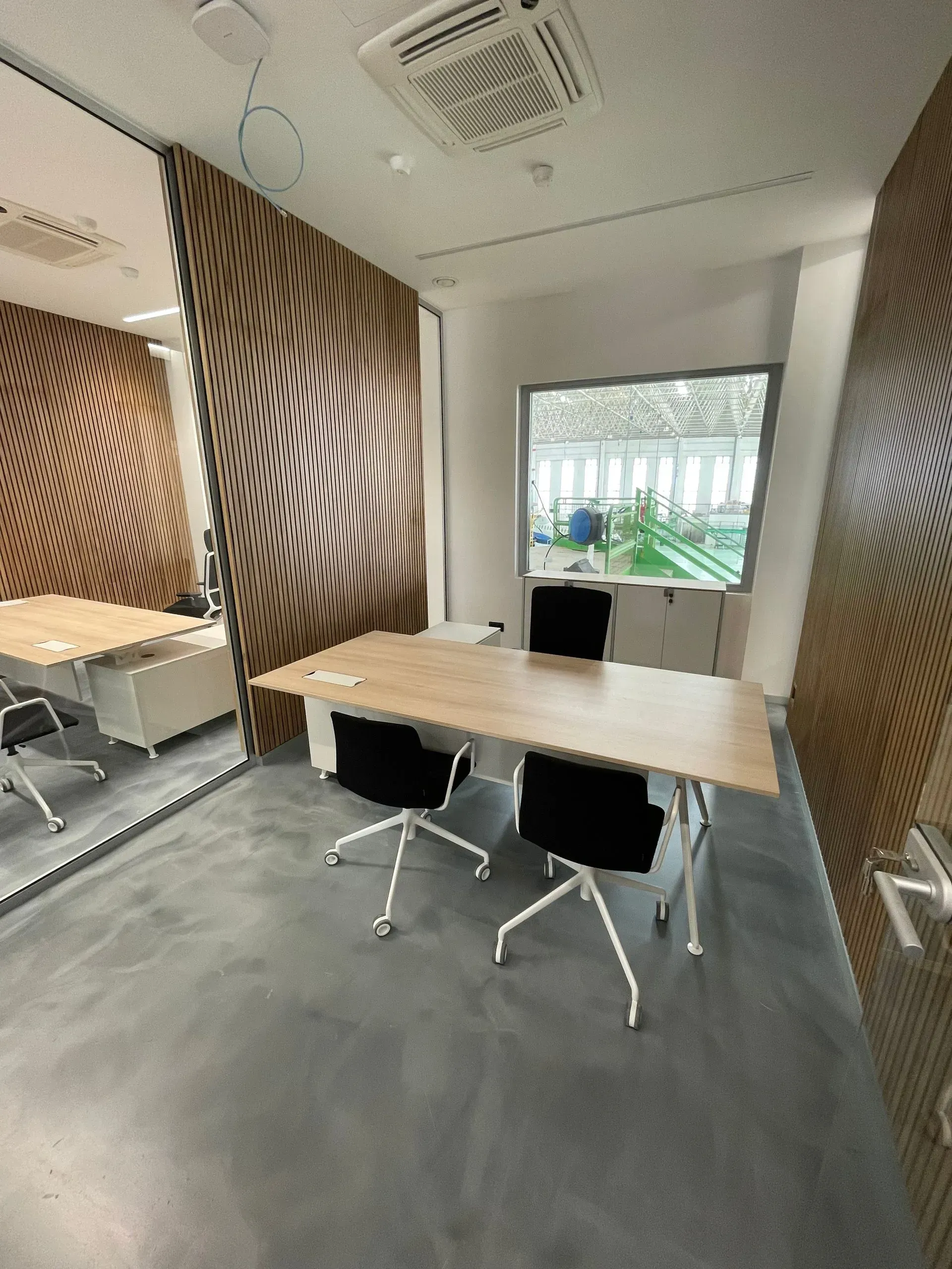 Una sala de conferencias con una mesa y sillas y una ventana grande.