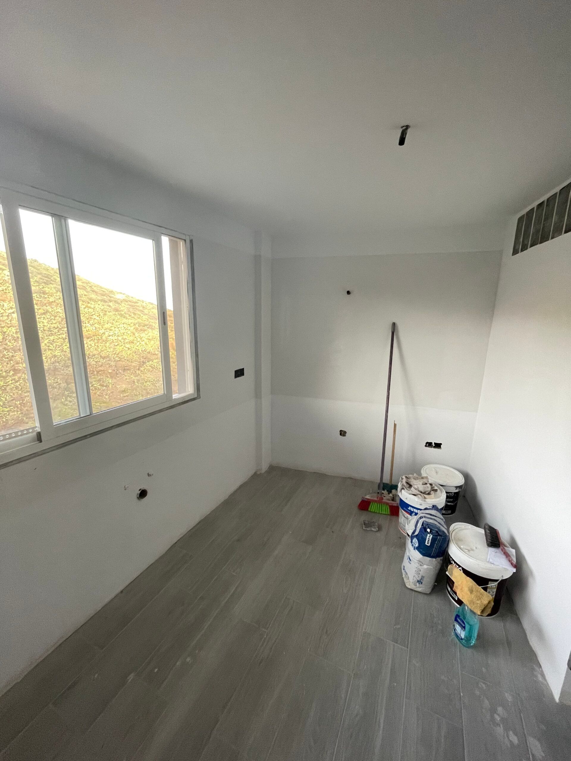 Una habitación vacía con paredes blancas y una ventana.