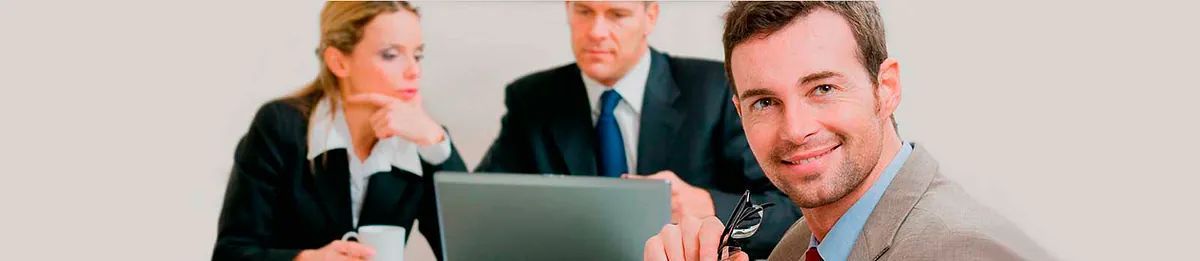 Un grupo de hombres de negocios están sentados alrededor de una mesa con una computadora portátil.