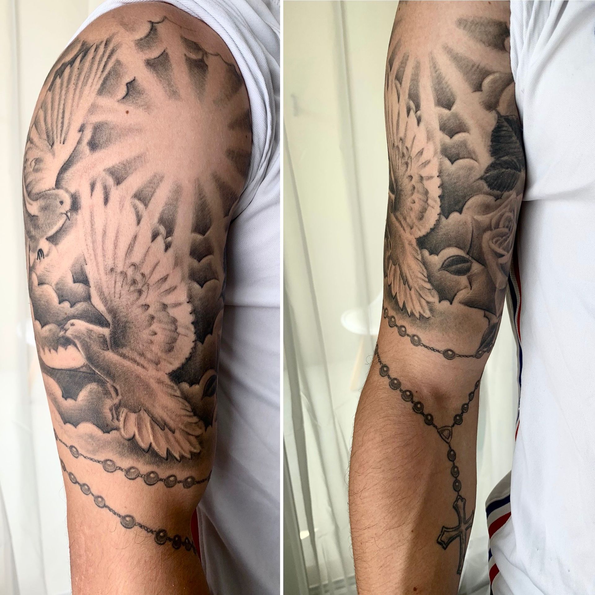 Gros plan en deux parties d'un tatouage en niveaux de gris sur le bras, représentant deux colombes, des nuages, des rayons de soleil et un chapelet drapé.
