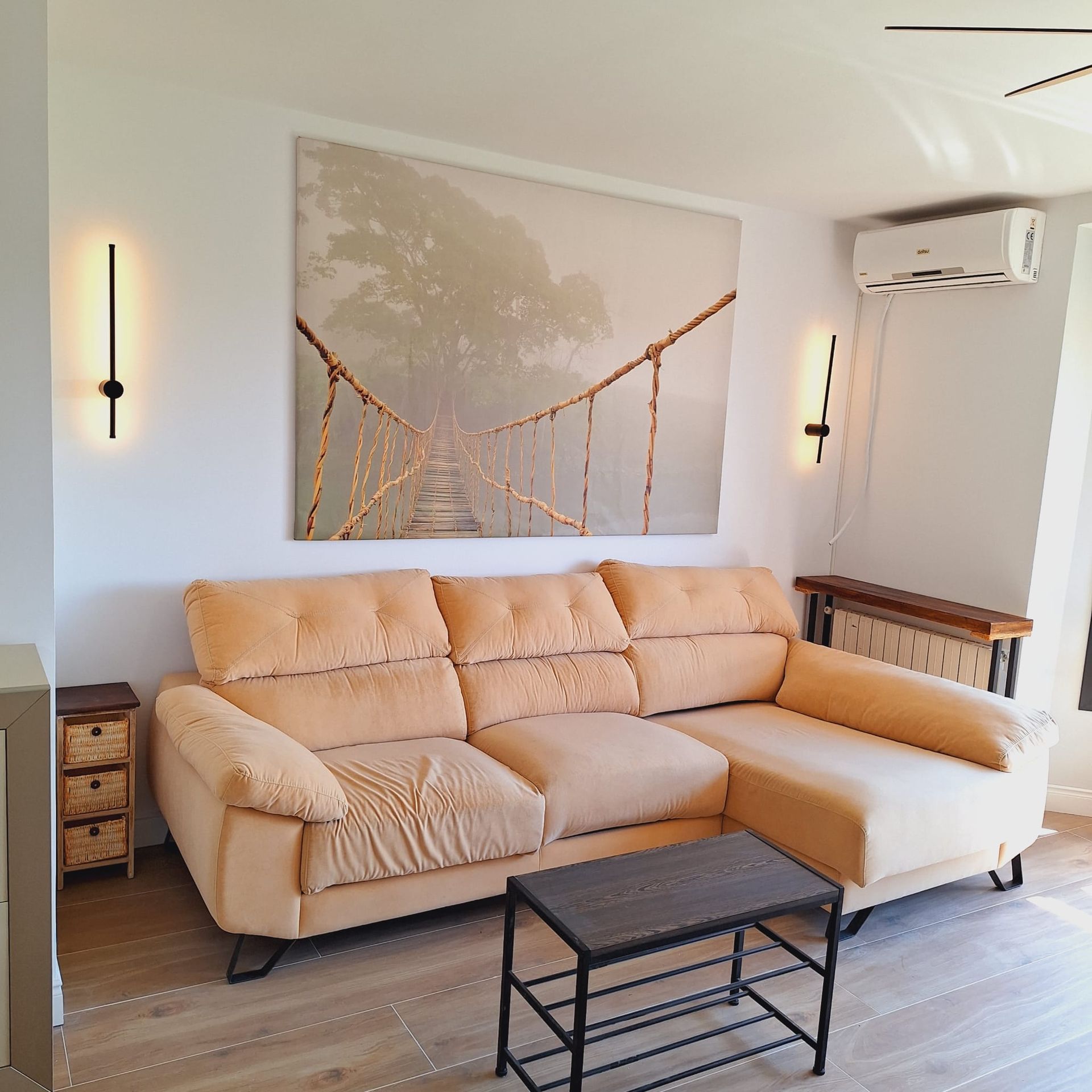 Una sala de estar con un sofá y un televisor de pantalla plana.