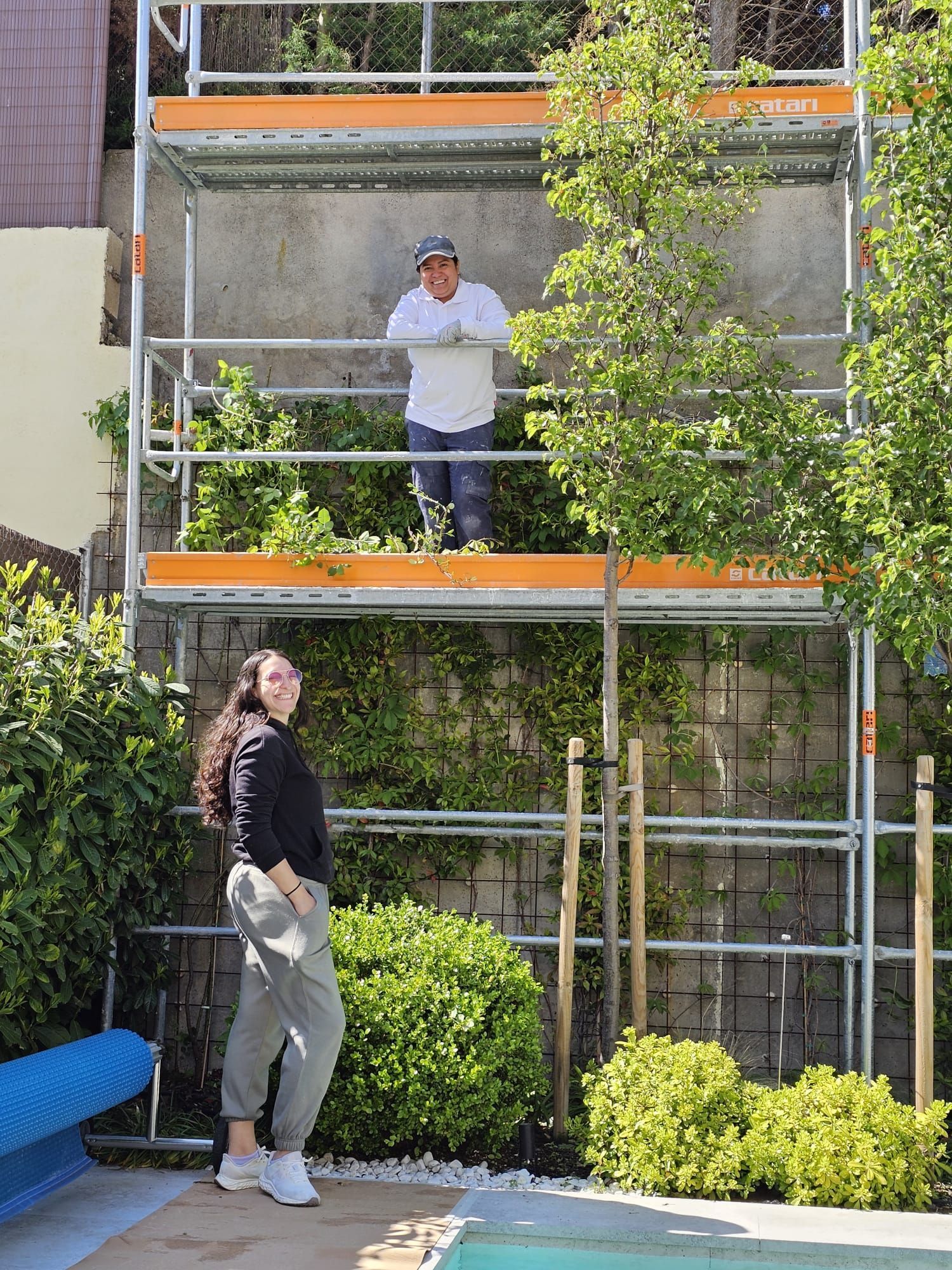 Un hombre con un chaleco amarillo está trabajando en una pared.