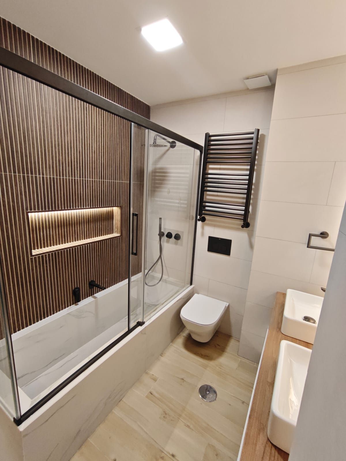 Un baño con lavabo, inodoro, ducha y espejo.