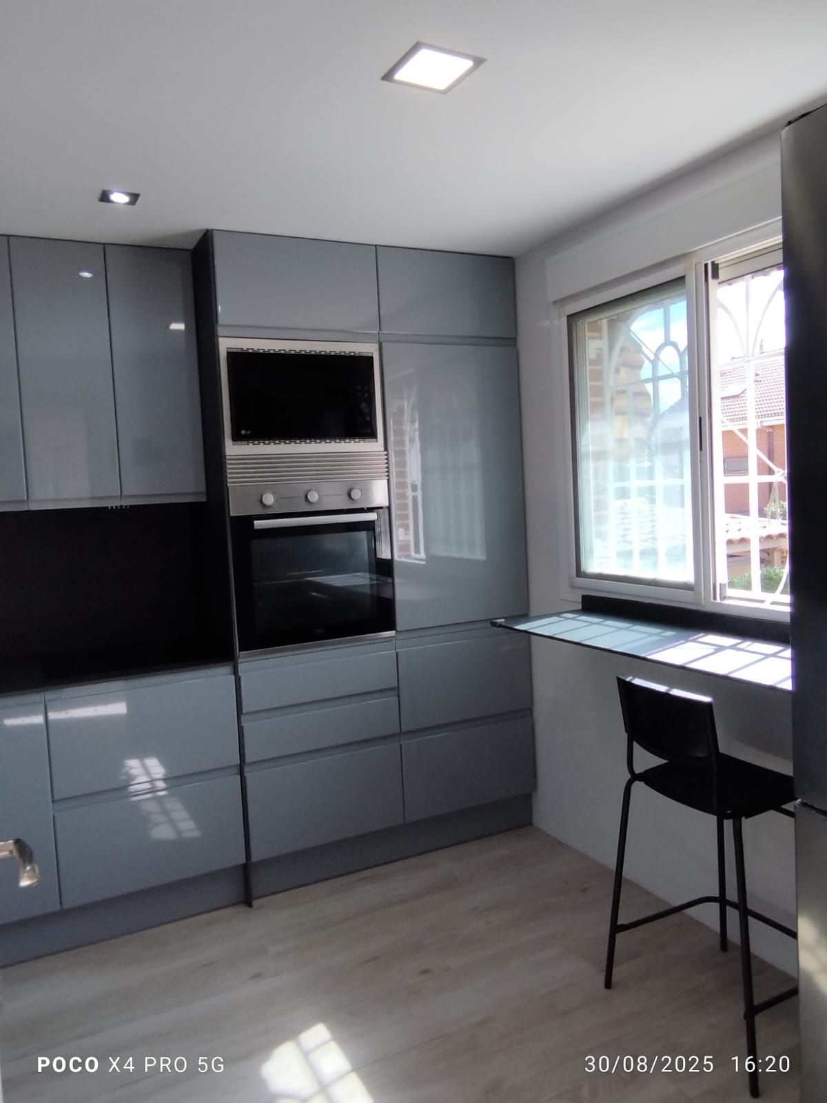 Una cocina con estufa y una ventana con plantas en macetas en el alféizar.