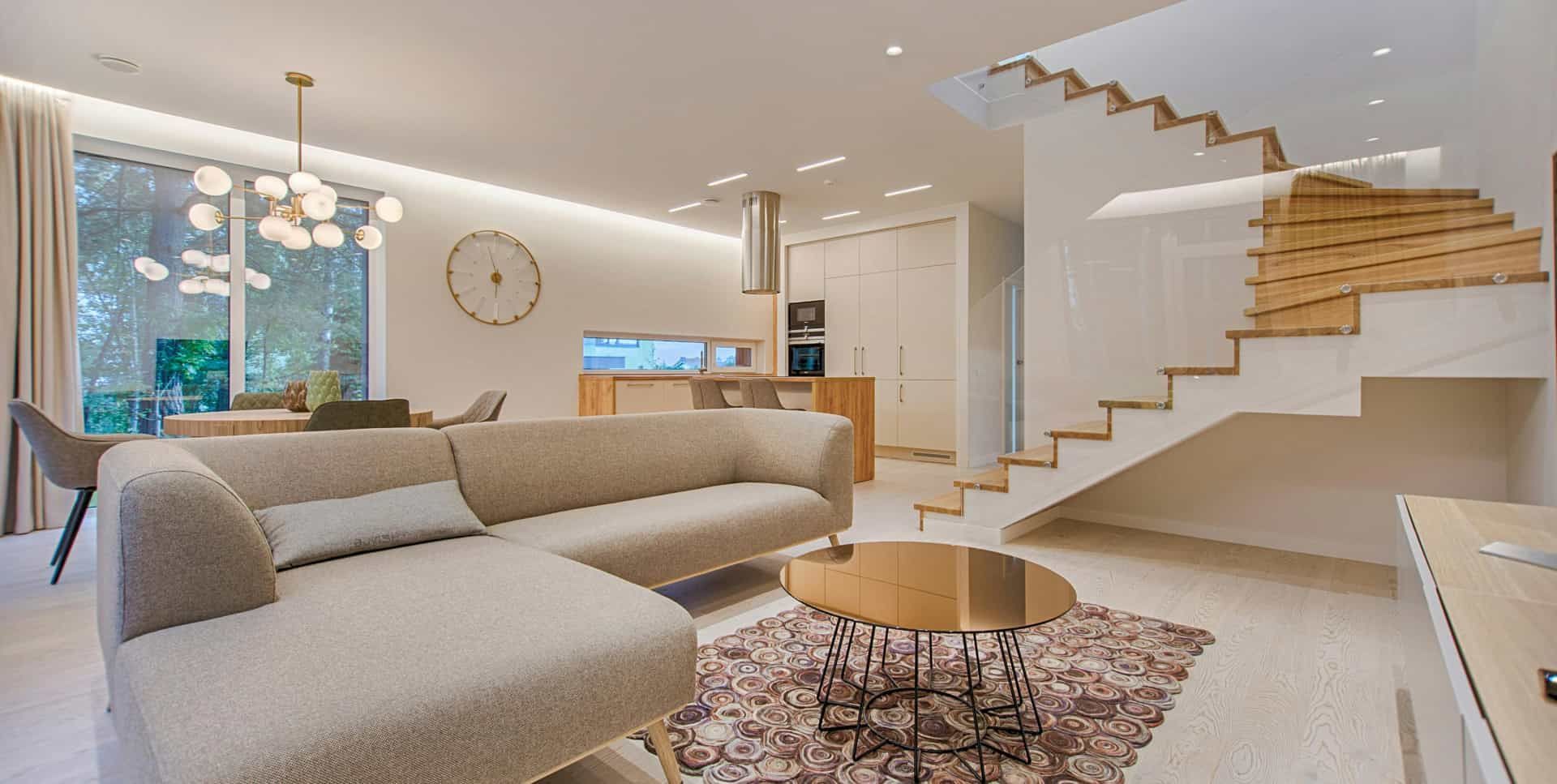 Una sala de estar con sofá, mesa y escaleras.