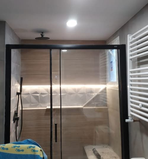 Un baño con una puerta de ducha corrediza de cristal.