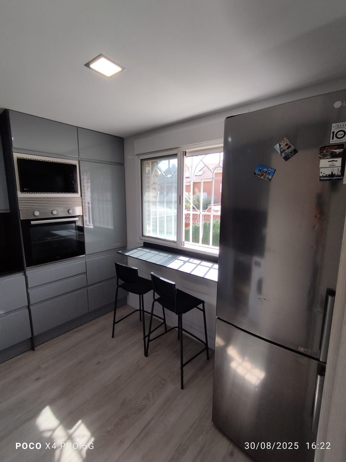 Una cocina con pisos a cuadros blancos y negros y gabinetes blancos.