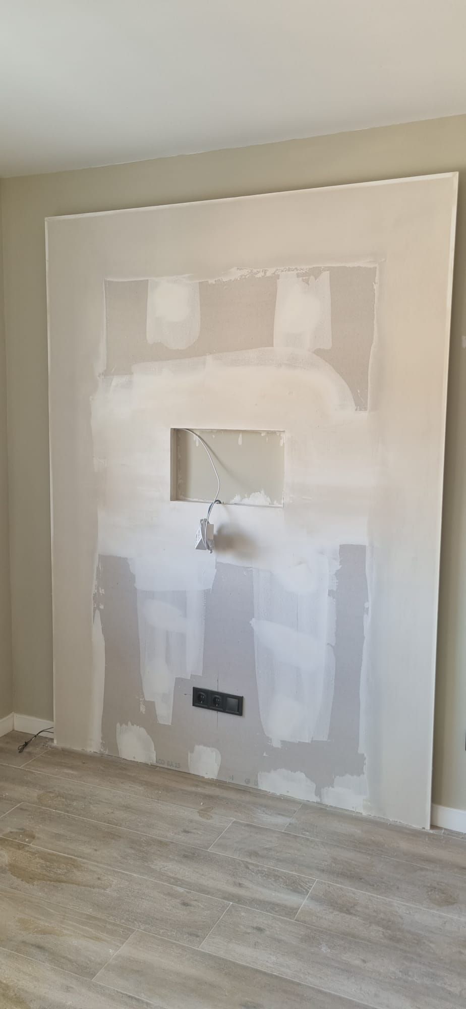 Se está construyendo una gran pared con secciones recortadas para una chimenea eléctrica.