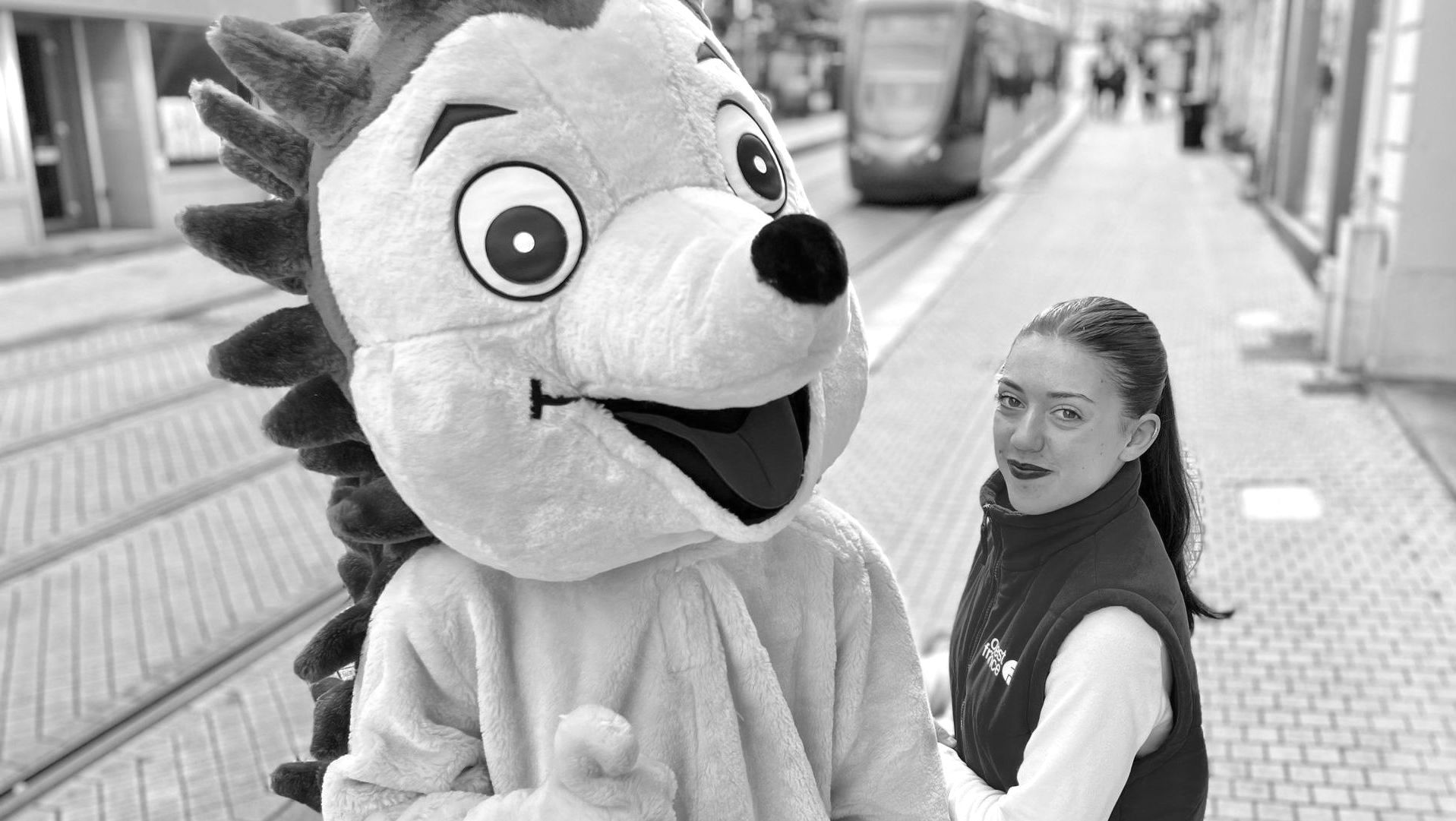 Une jeune femme et une mascotte