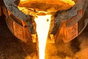 Stahlindustrie Geschmolzenes Metall fließt aus einem glühenden Gießereitiegel