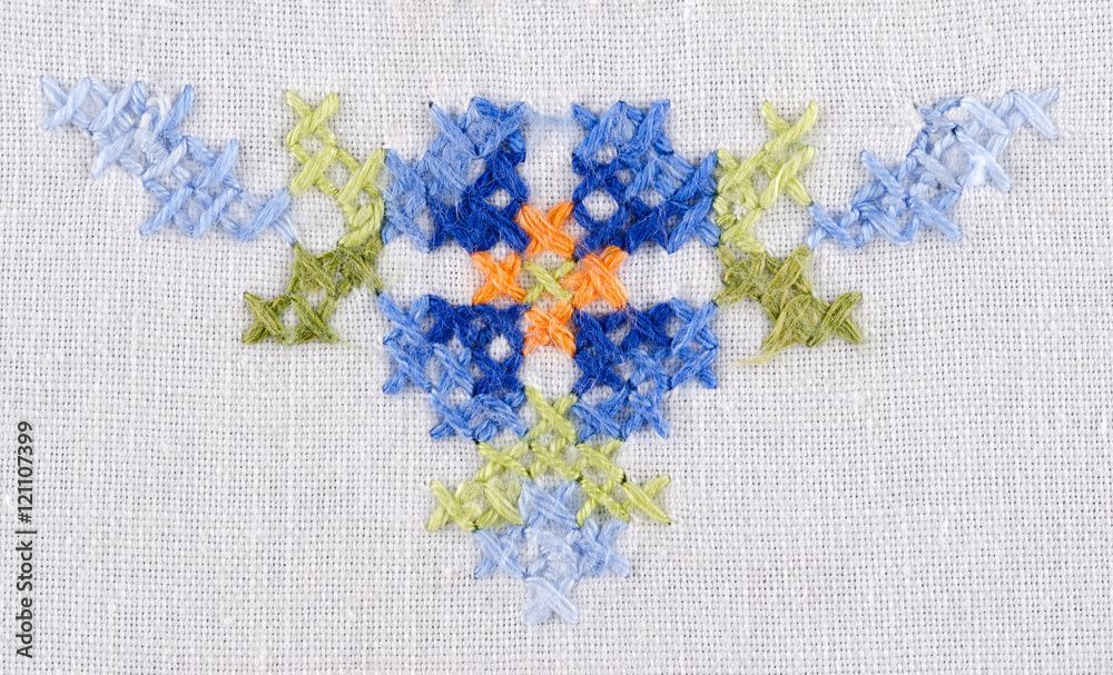 Un gros plan d'un motif de point de croix sur un morceau de tissu.