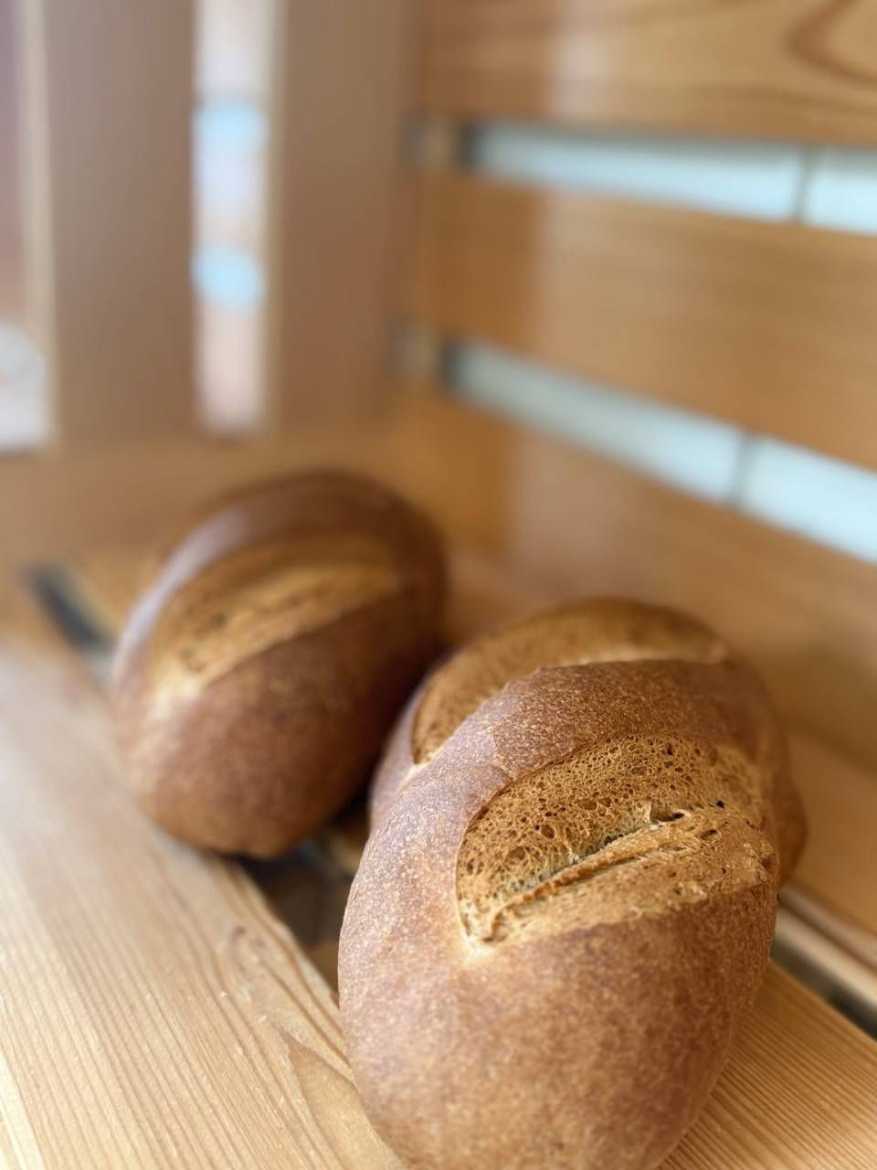 Deux pains sont posés sur un banc en bois.
