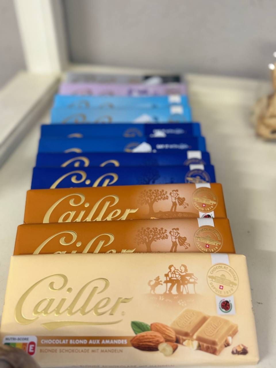 Une rangée de barres de chocolat Cailler est alignée sur une table