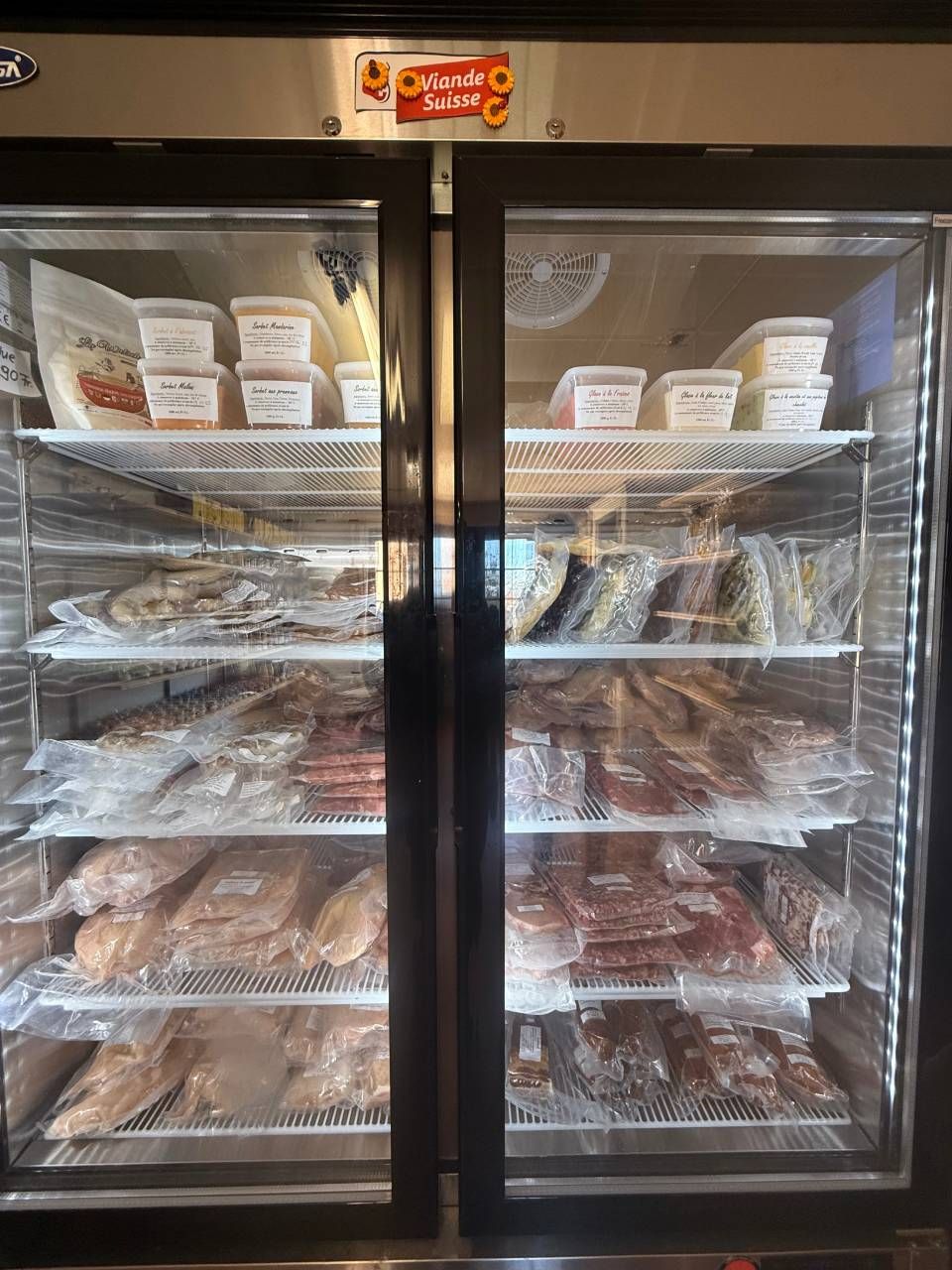 Un réfrigérateur rempli d'une variété de viandes et de légumes.