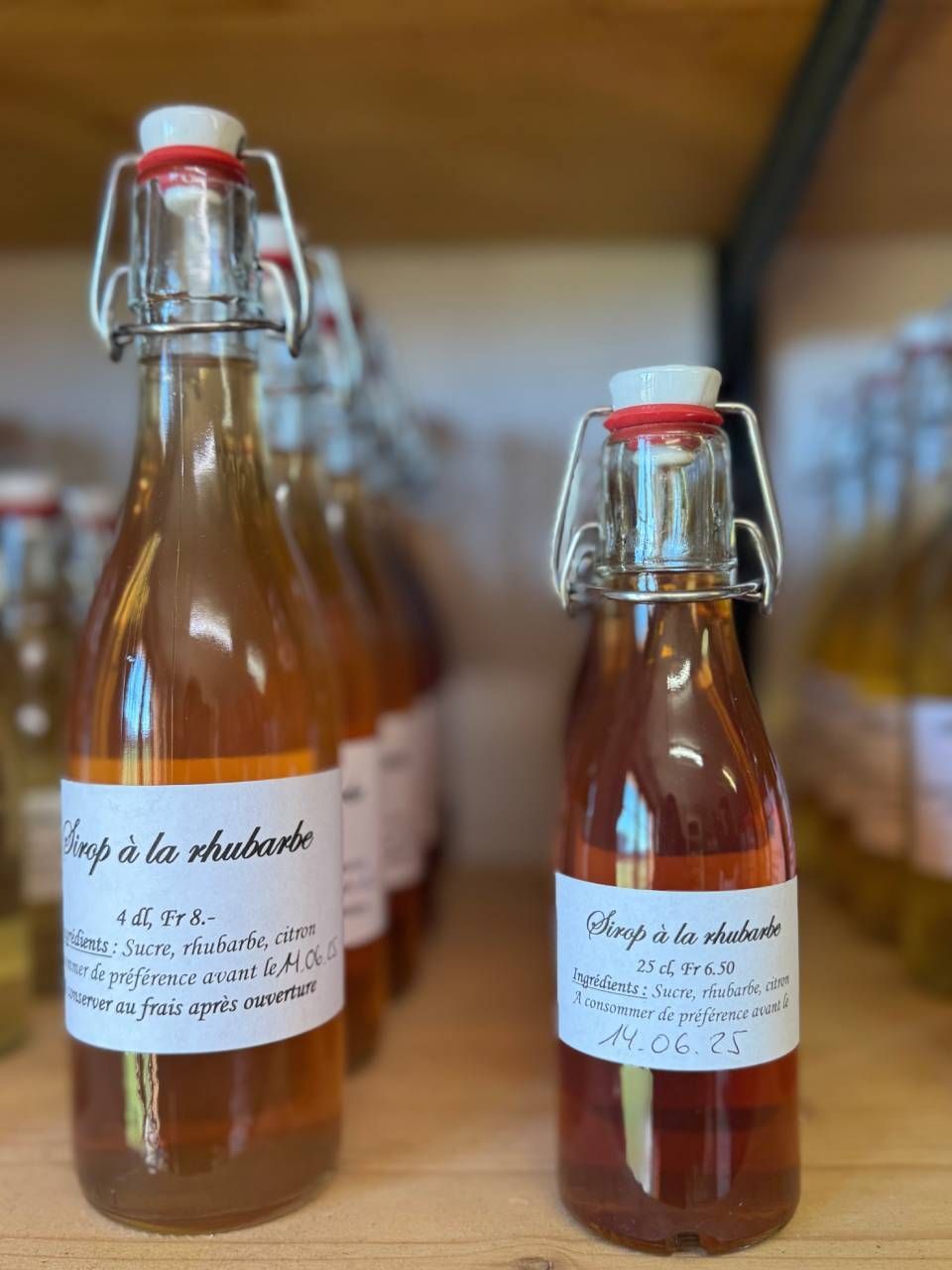 Deux bouteilles de sirop sont posées sur une étagère en bois.