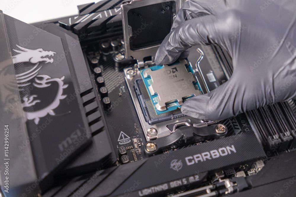 Eine behandschuhte Hand installiert eine CPU in einen Sockel auf einem MSI Carbon-Motherboard.