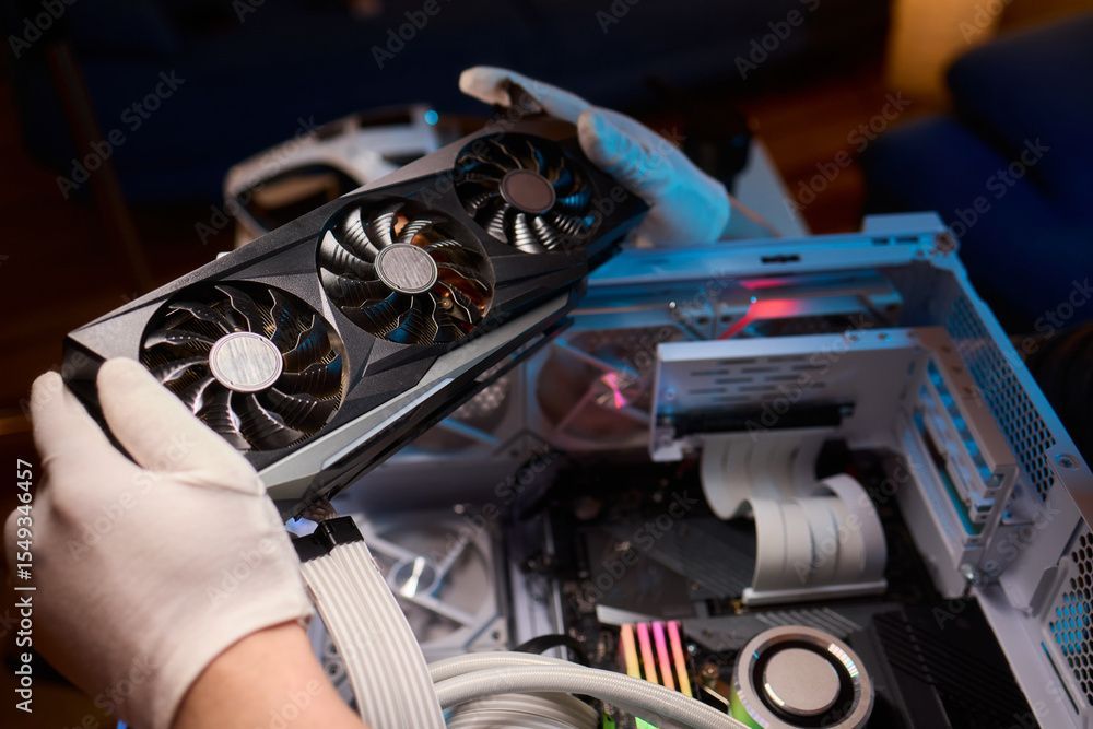 Behandschuhte Hände installieren eine Grafikkarte in einem offenen Computergehäuse