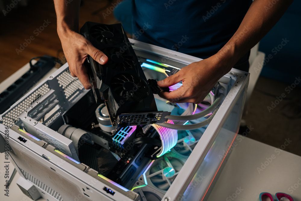 Eine Person installiert eine Grafikkarte in einen Desktop-PC mit farbenfroher RGB-Beleuchtung