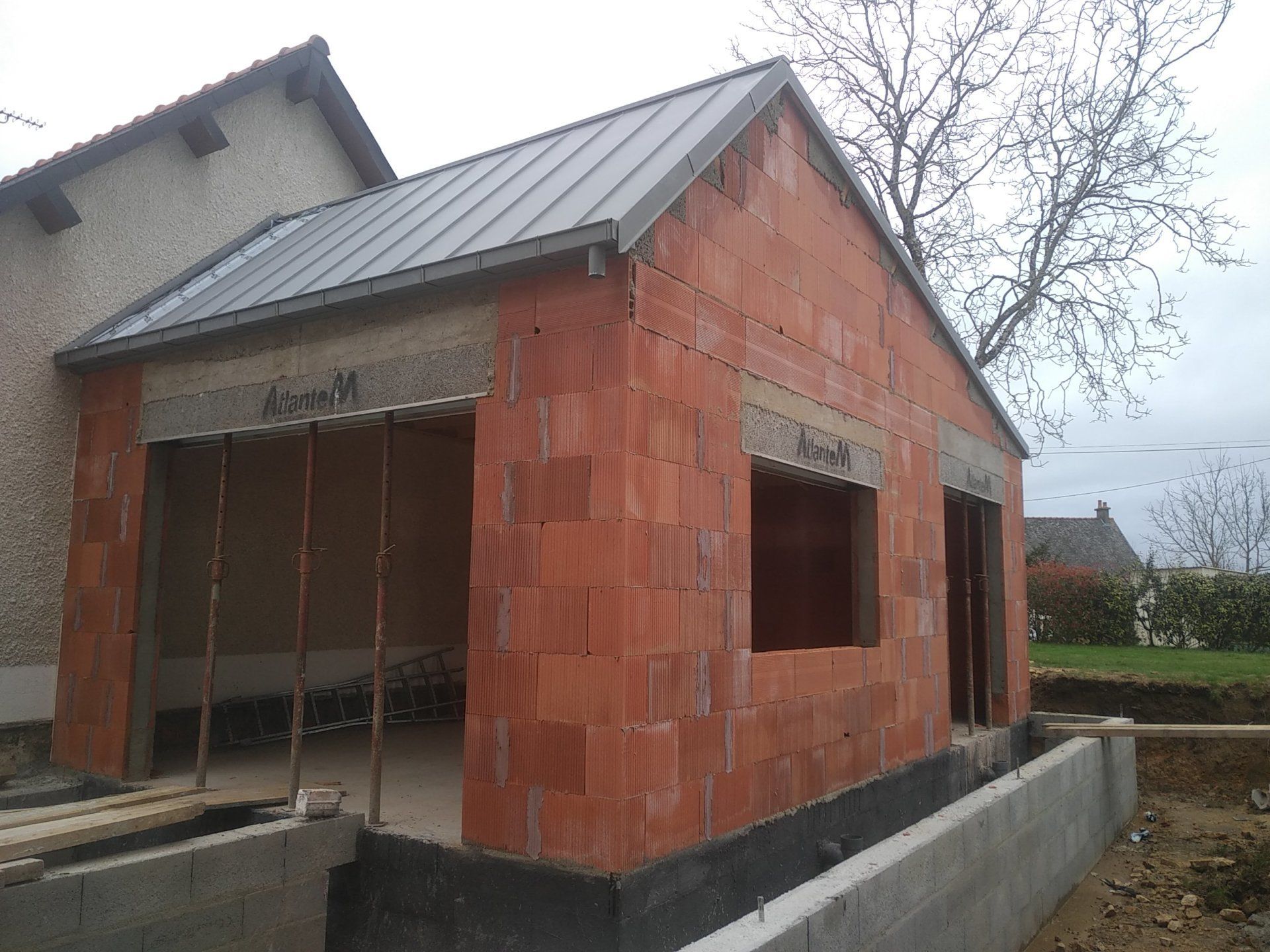 Extension de maison en brique rouge avec couverture en zinc