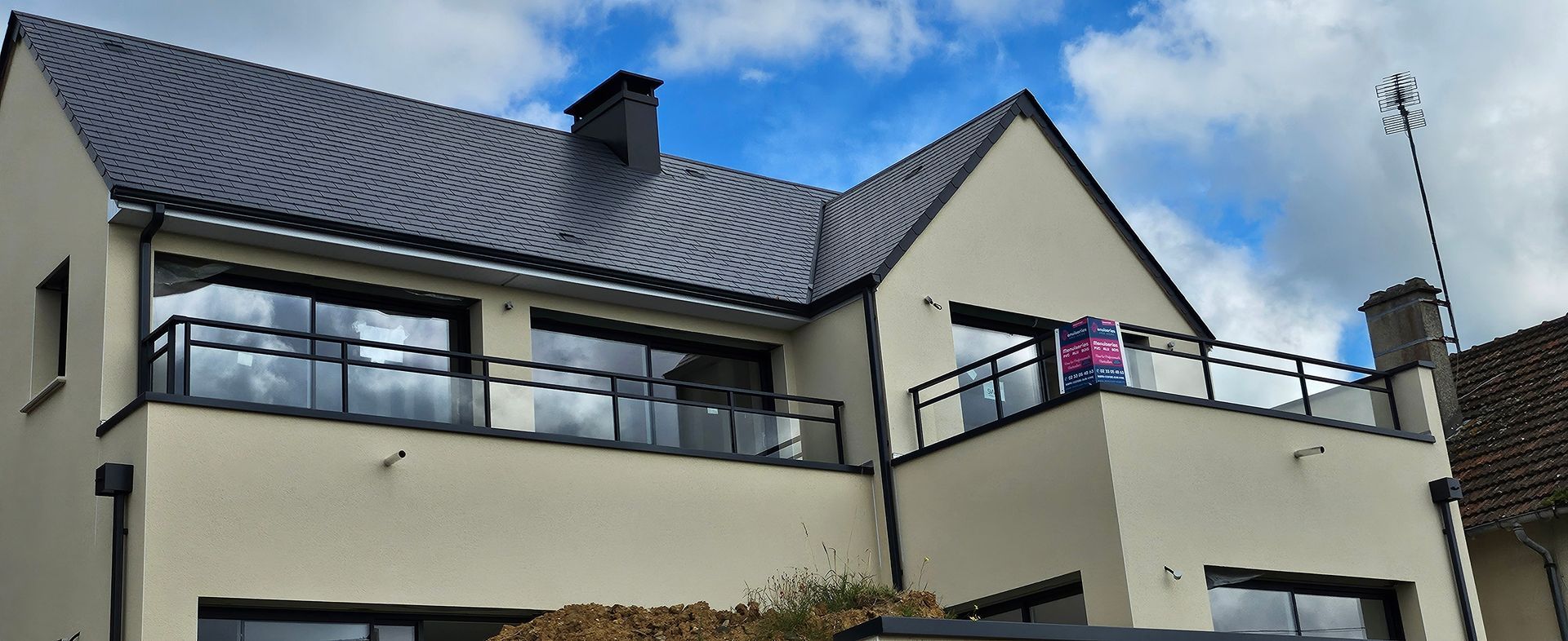 Maison avec terrasse en hauteur et garde-corps.
