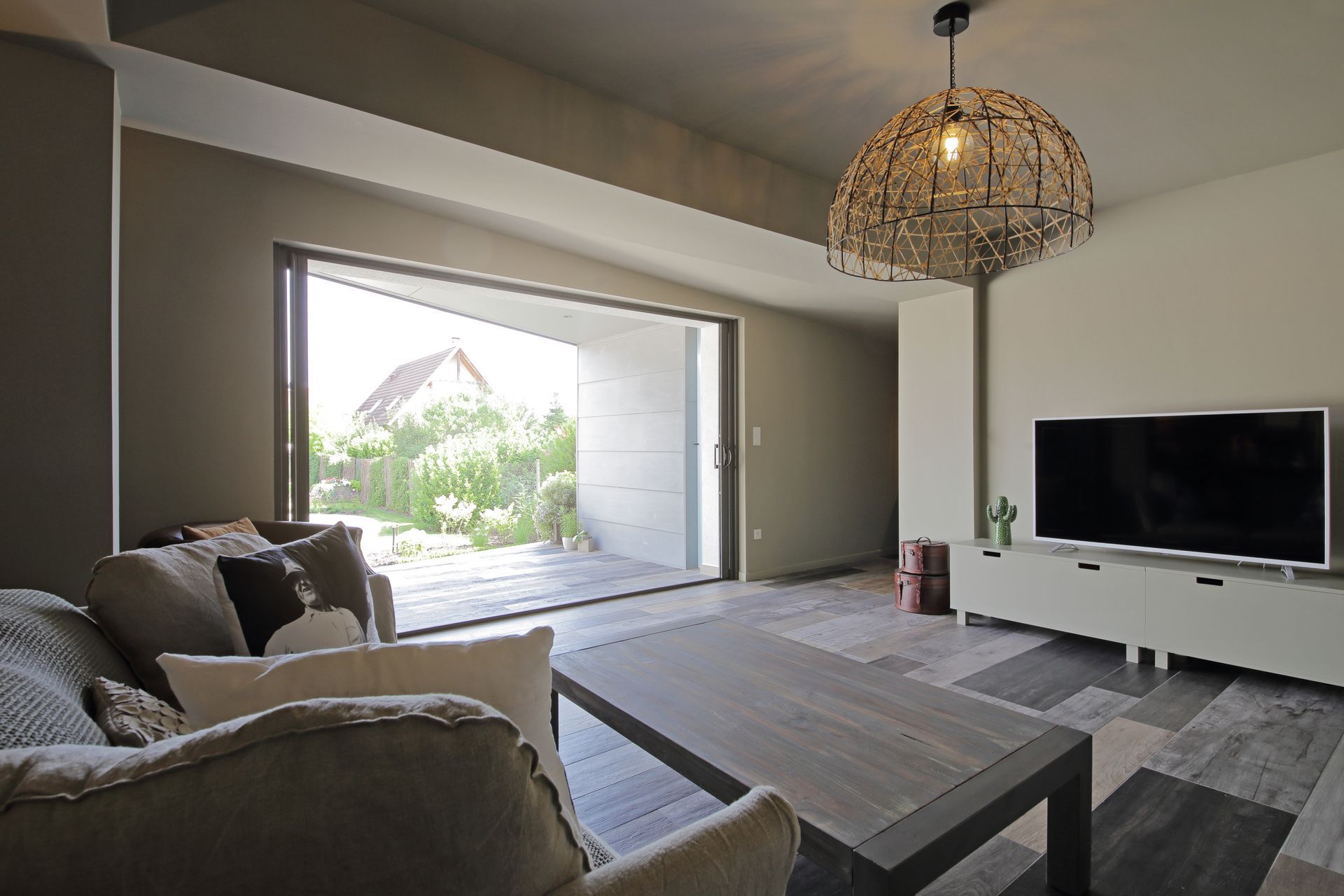 Grande baie vitrée en aluminium qui donne sur l'intérieur d'un salon.