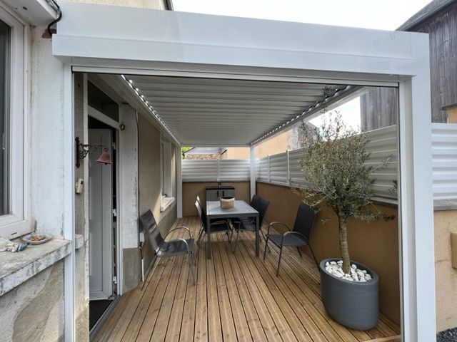 Pergola au dessus d'une terrasse en bois.