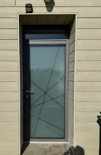 Porte moderne avec verre dépoli et design géométrique, sertie dans un revêtement beige.