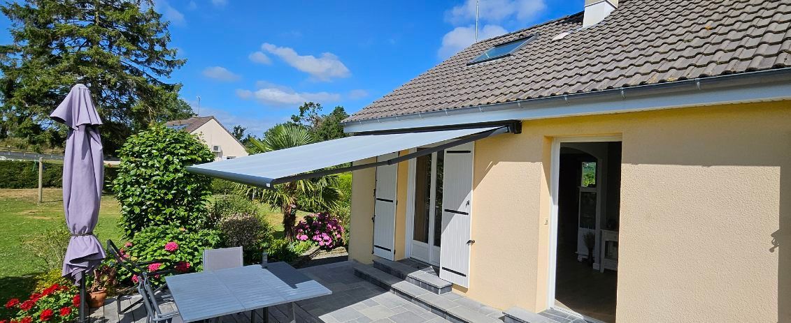 Store banne gris sur la terrasse d'une maison.