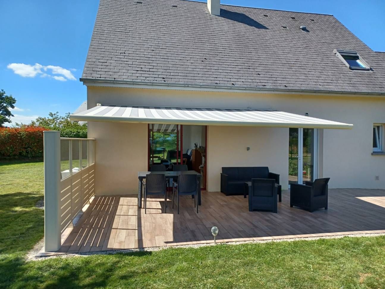 Store banne au-dessus d'une terrasse en bois.