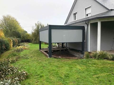 Maison à deux étages avec toit gris et pergola grise moderne sur une terrasse en bois sur la pelouse.