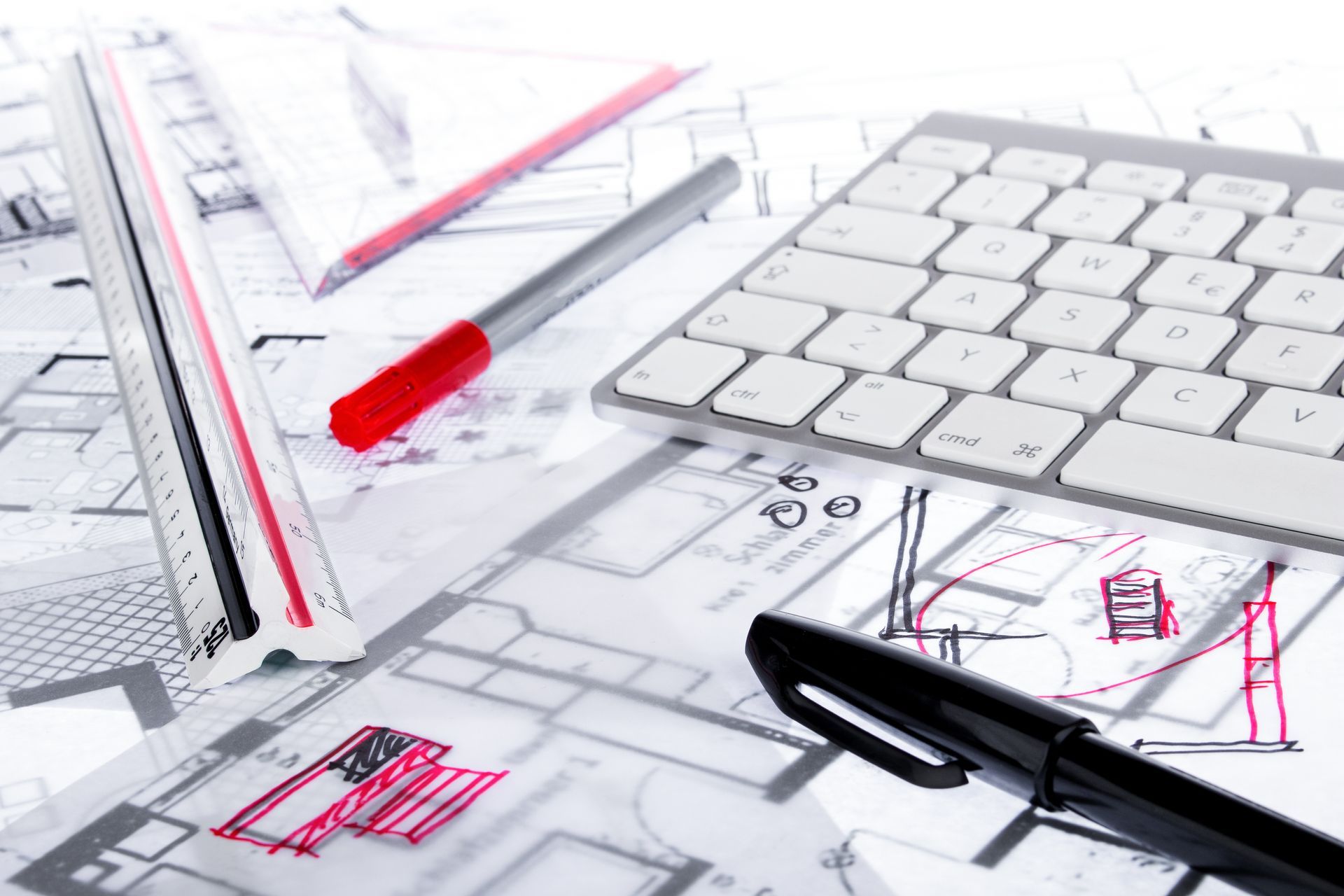 Zwei Personen an Tisch, Laptop und Baupläne