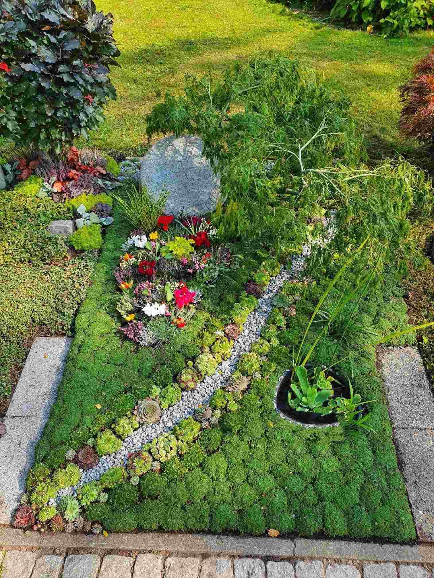 Ein Friedhof voller grüner Pflanzen und Blumen.