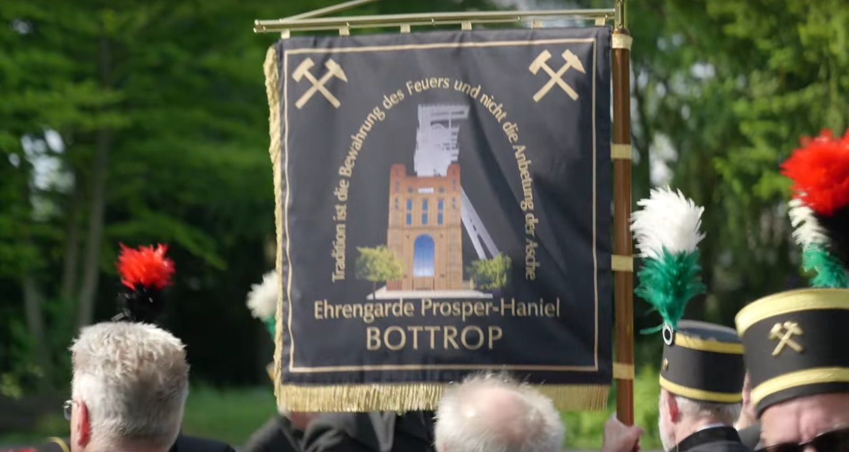 Banner mit Bergbausymbolen, einer Schachtillustration und „Ehrengarde Prosper-Haniel BOTTROP“. Schwarzer Hintergrund, Außenkulisse.