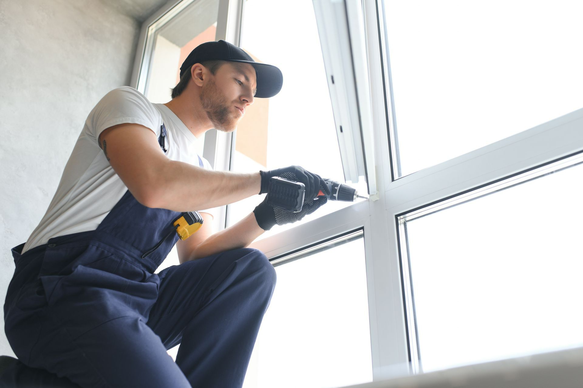 Artisan qui fixe une fenêtre en pvc