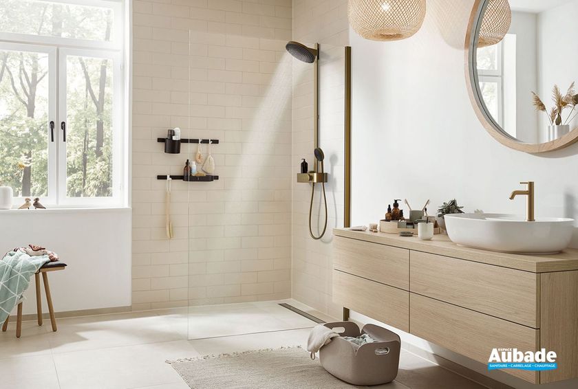Salle de bains lumineuse avec douche à l'italienne, meuble-lavabo en bois, miroir rond et suspensions lumineuses en osier.