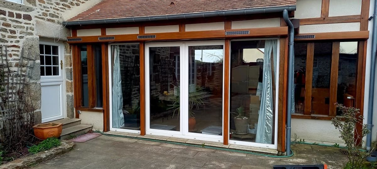 Maison de pierre avec baies vitrées en bois