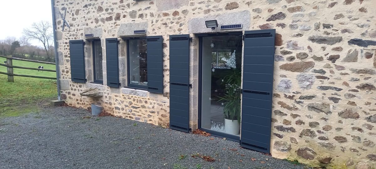 Volets bleus pour maison de campagne avec murs en pierre