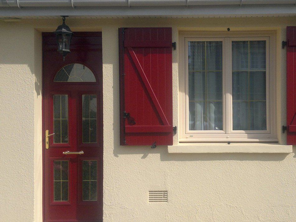 Porte et fenêtre aux volets rouges
