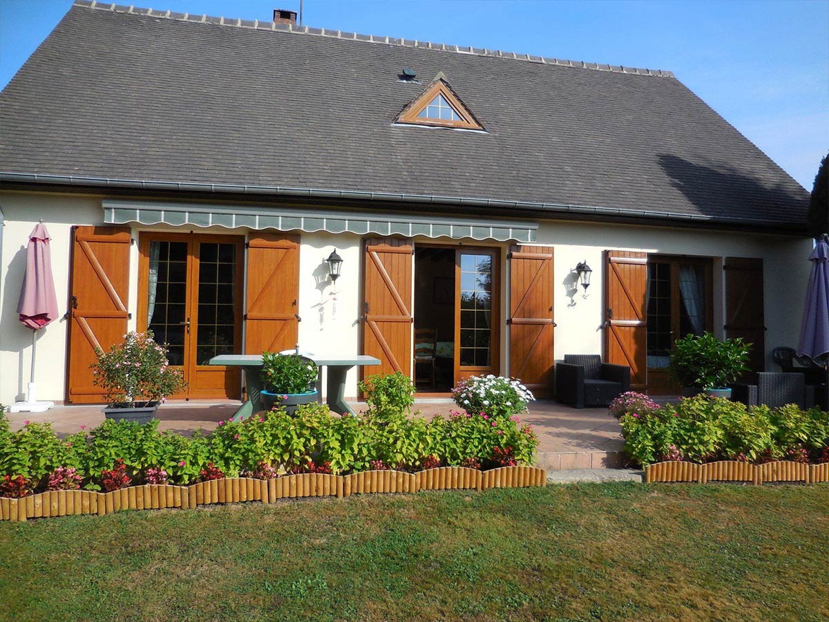 Porte-fenêtre d'une maison aux volets en bois