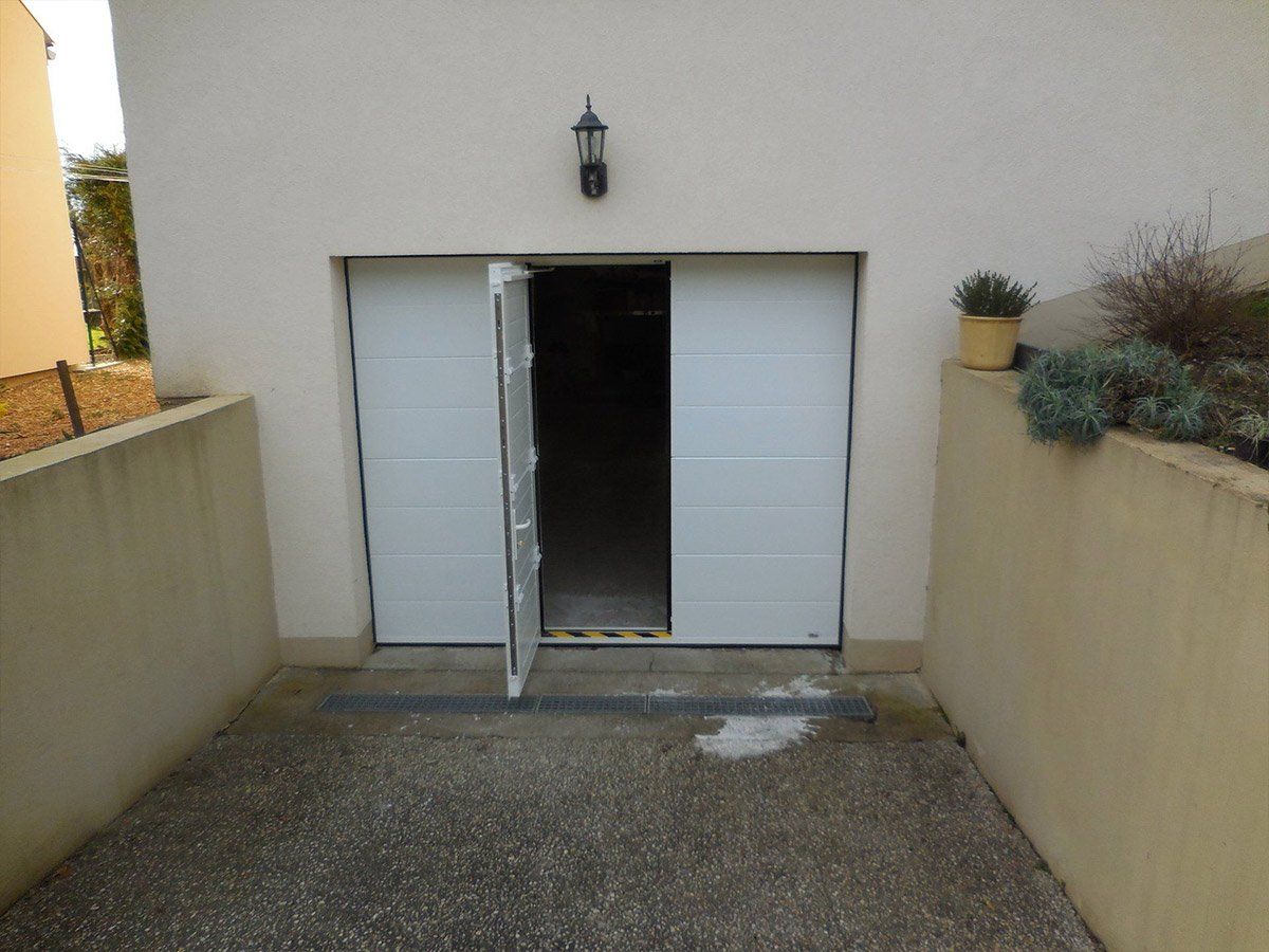 Porte de garage avec une ouverture battante de couleur blanche