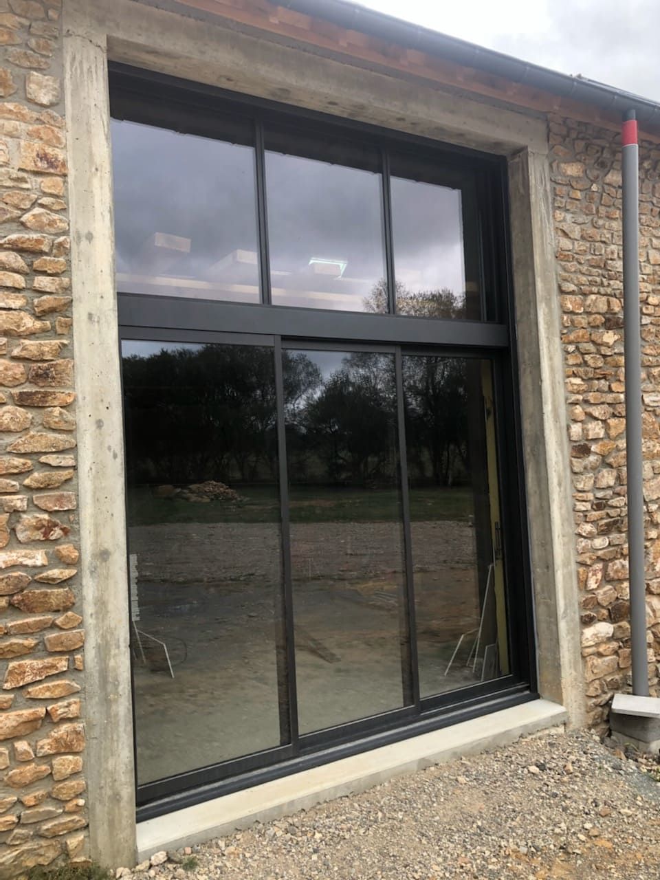 Grande porte fenêtre noire avec vitres au dessus