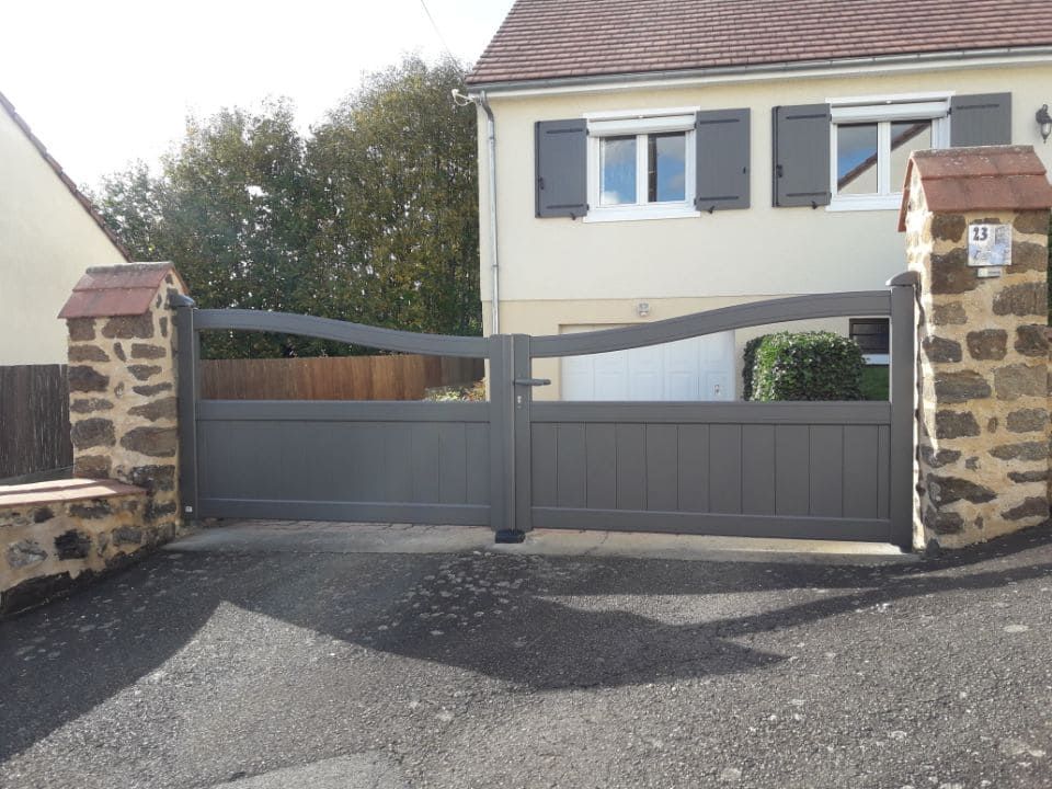 Portail gris avec espace vide sur mur en pierre