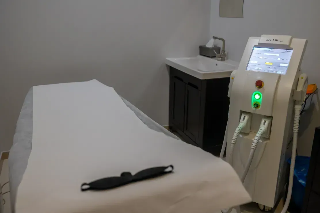 Una máquina está sobre una mesa en una habitación al lado de un fregadero.