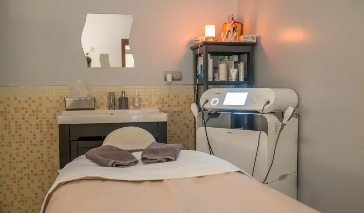 Una mesa de masajes en una habitación con lavabo y espejo.