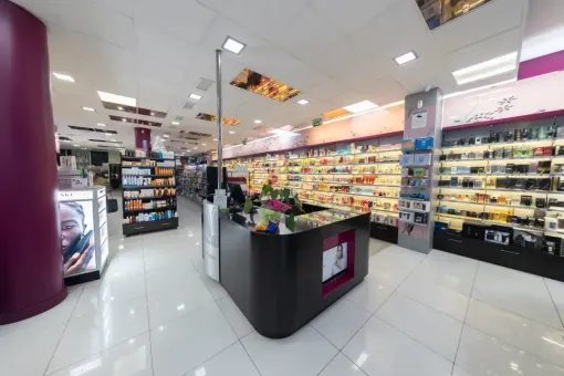 El interior de una farmacia con un mostrador en el medio de la habitación.
