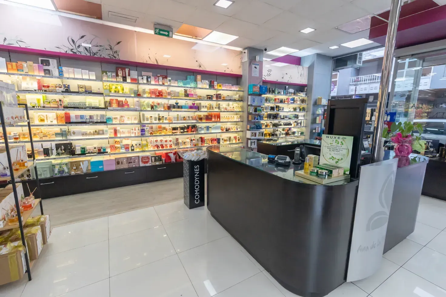 Una farmacia con muchos estantes y un mostrador.