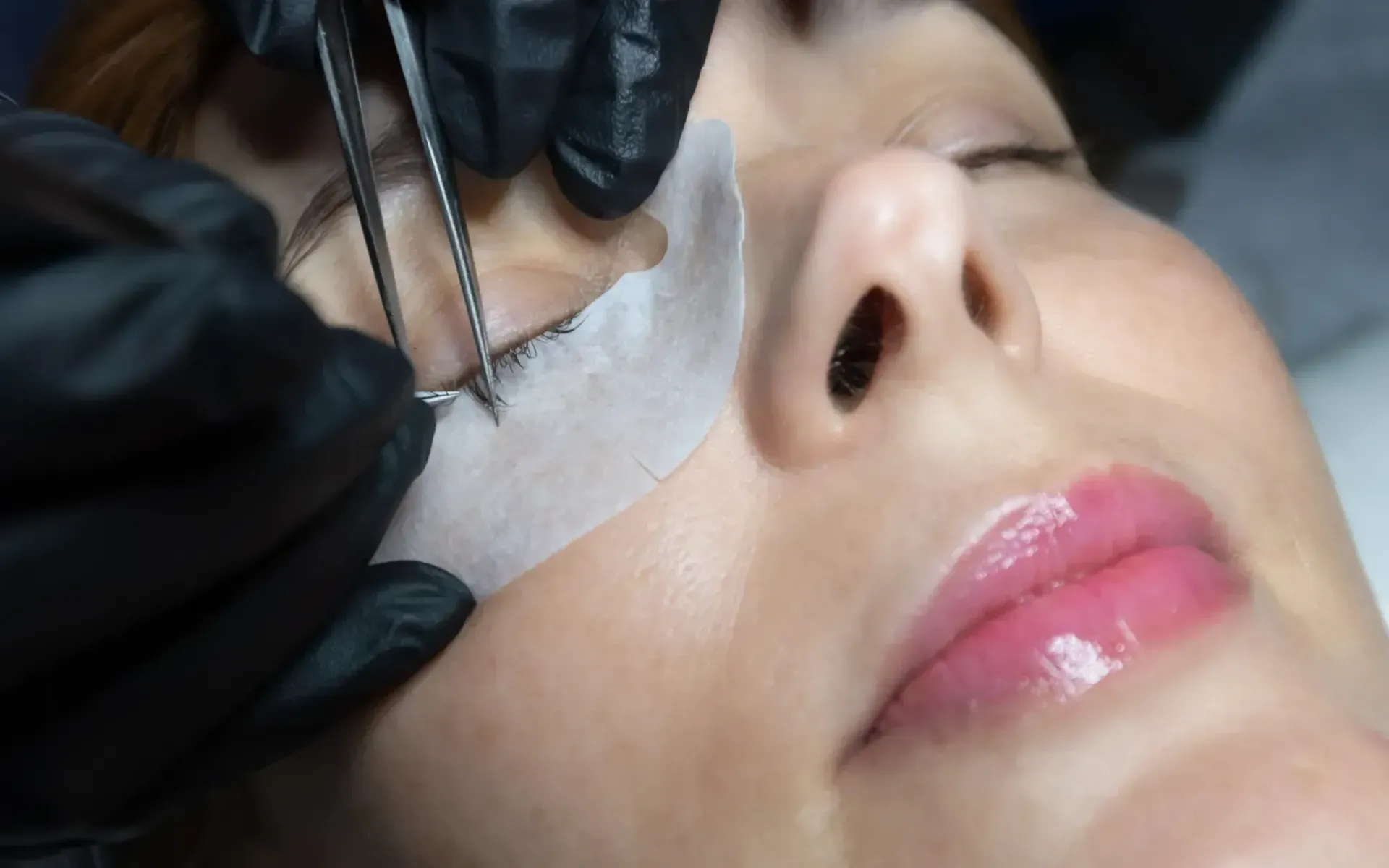 Una mujer se está haciendo las pestañas en un salón de belleza.