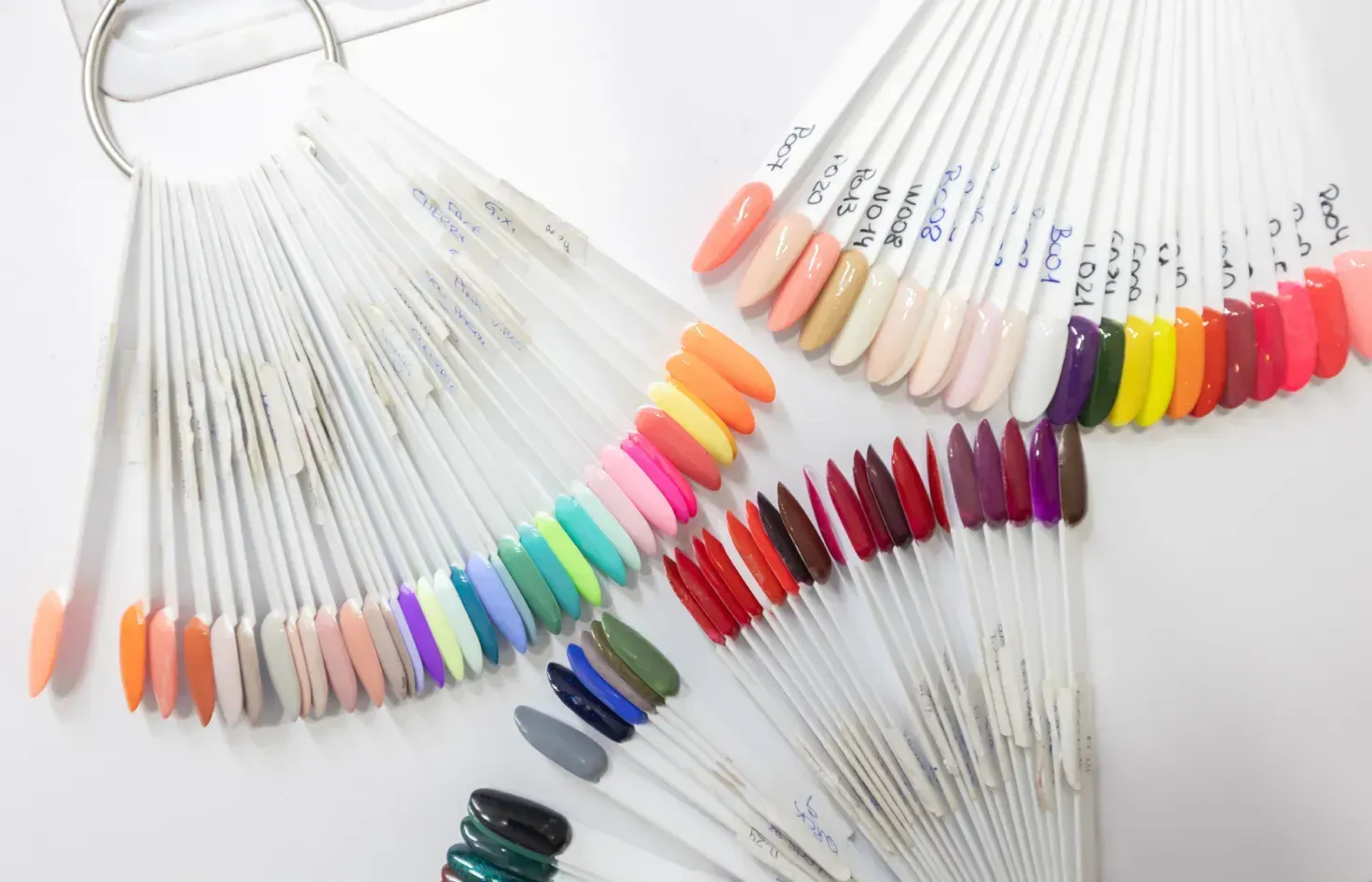 Un montón de uñas de diferentes colores están sobre una mesa.