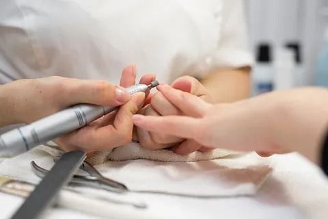Una mujer se está haciendo las uñas en un salón de uñas.
